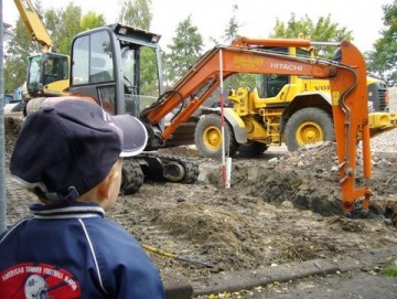 jongentje bij bouwplaats, buldozer en graafmachine jongentje bij bouwplaats, buldozer en graafmachine
